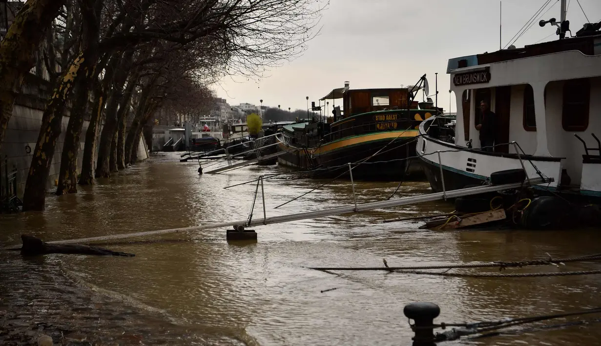 Sejumlah kapal tongkang bersandar saat sungai Seine di Paris meluap, Prancis (6/1). Sungai Seine tidak mampu menampung debit air setelah hujan terjadi terus-menerus. (AFP Photo/Olivier Morin)