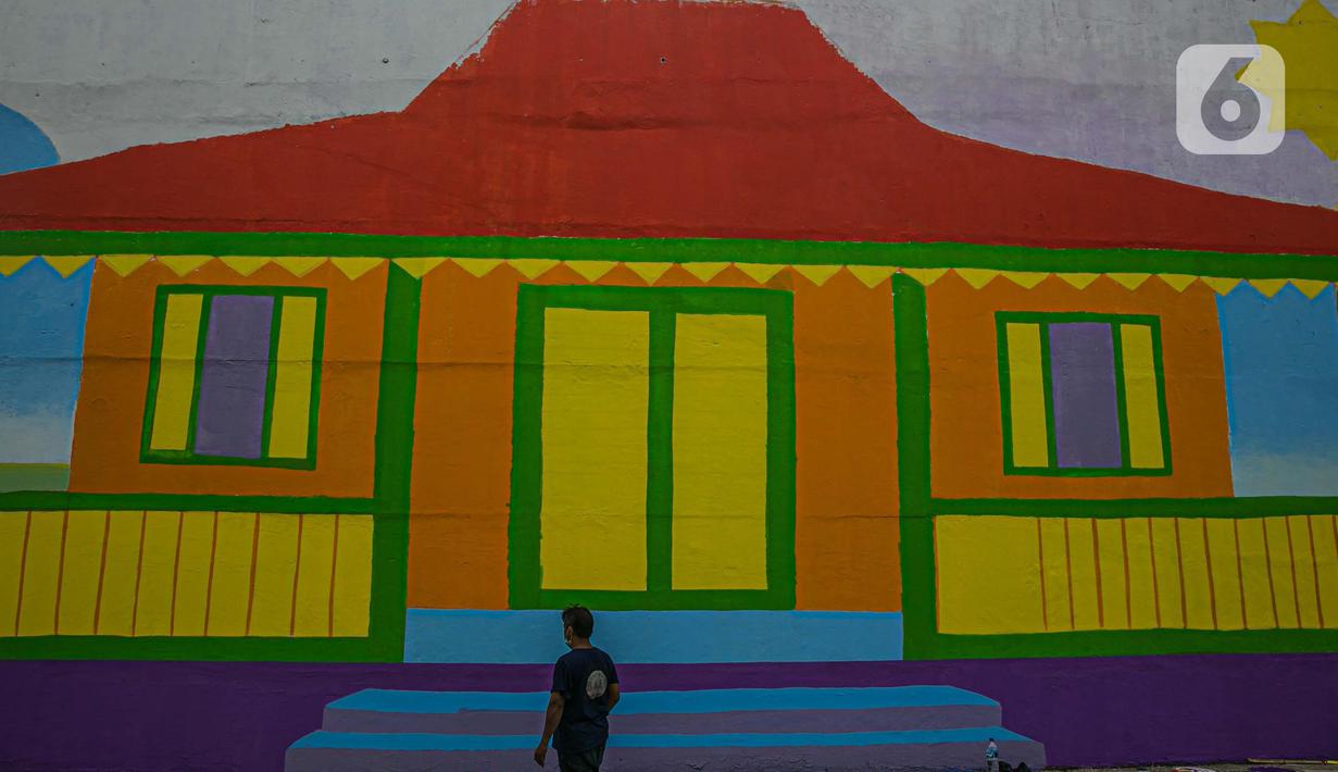 Pekerja melihat mural di Flyover Gaplek, Tangerang Selatan, Rabu (10/3/2021). Dengan mengangkat budaya lokal, simbol-simbol Betawi digambar menggunakan 1.200 Liter cat beragam warna. dan mural ditargetkan rampung pada akhir Maret 2021. (Liputan6.com/Faizal Fanani)