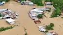 Sedikitnya dua orang dilaporkan tewas, sementara lebih dari satu juta warga telah dievakuasi dari jalur lintasan badai tersebut. Tampak foto udara menunjukkan pemandangan rumah-rumah yang terendam banjir di Kota Tuguegarao, Provinsi Cagayan, di utara Manila pada 10 November 2025, setelah sungai meluap akibat hujan deras yang disebabkan oleh Topan Super Fung-wong. (John DIMAIN/AFP)