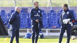 Pelatih sementara timnas Inggris, Gareth Southgate (tengah) saat berbincang dengan asistennya pada sesi latihan persiapan melawan Malta di St George's Park,  Burton-upon-Trent, (4/10/2016). AFP/Paul Ellis)