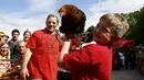 Seorang peserta bersama ayam betinanya merayakan kemenangan dalam World Hen Racing Championships di Bonsall, Inggris, Sabtu (1/8/2015). Sejumlah ayam betina adu kecepatan untuk menjadi pemenang dalam kejuaran tersebut. (Reuters/Darren Staples)