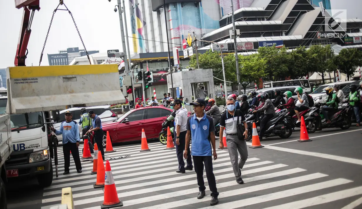 Petugas Dishub memindahkan separator beton untuk menutup sebagian jalan di depan kantor Bawaslu RI, Jakarta, Selasa (21/5/2019). Aparat kepolisian memperketat penjagaan gedung Bawaslu untuk aksi 22 Mei atau setelah penetapan hasil rekapitulasi suara Pemilu 2019 oleh KPU. (Liputan6.com/Faizal Fanani)