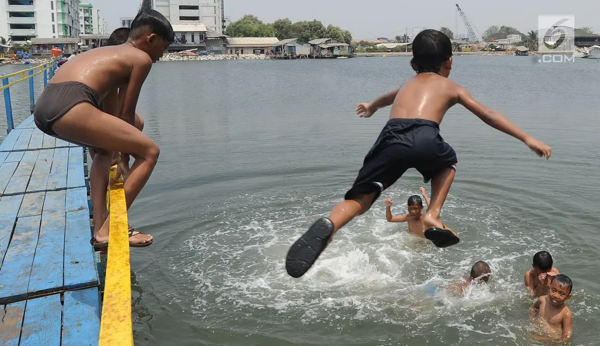 Anak-anak berenang dan bermain air dekat tanggul laut Muara Baru di Penjaringan, Jakarta Utara, Minggu (1/9/2019). Anak-anak memanfaatkan sisi tanggul laut raksasa (giant sea wall) sebagai   tempat  bermain alternatif. (merdeka.com/Arie Basuki)