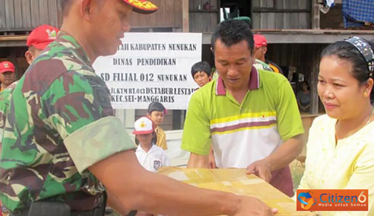 Citizen6, Nunukan: Wadan Sub Korwil 05 Tim Ekspedisi khatulistiwa 2012 Kabupaten Nunukan Mayor Inf Achiruddin, menyerahkan bantuan buku kepada seorang guru sukarelawan, Ny. Sarlota, Senin (2/7). (Pengirim: Badarudin Bakri)