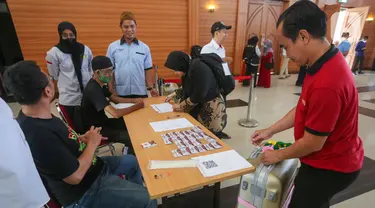 Petugas sedang merapikan koper petugas PPIH di asrama haji Pondok Gede, Jakarta, Selasa (31/5/2022). Petugas  PPIH (Petugas Panitia Penyelenggara Ibadah Haji) sebanyak di  828 orang di berangkatkan pada Rabu (1/6/2022) yang di bagi daerah kerja ke Jeddah, Madinah dan Mekkah. (Liputan6.com/Herman Zakharia)