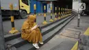 Seorang wanita mengoperasikan gawainya saat duduk di kawasan Pasar Tanah Abang, Jakarta, Senin (11/5/2020). Pemerintah Provinsi DKI Jakarta kembali memperpanjang penutupan sementara Pasar Tanah Abang hingga 22 Mei 2020 untuk mencegah penyebaran virus corona COVID-19. (Liputan6.com/Immanuel Antonius)