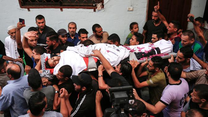 Pelayat membawa jasad paramedis Palestina Abdullah al-Qutati di Rafah, Jalur Gaza, Sabtu (11/8). Abdullah al-Qutati ditembak tentara Israel saat bertugas dalam demo Great March of Return. (SAID KHATIB/AFP)