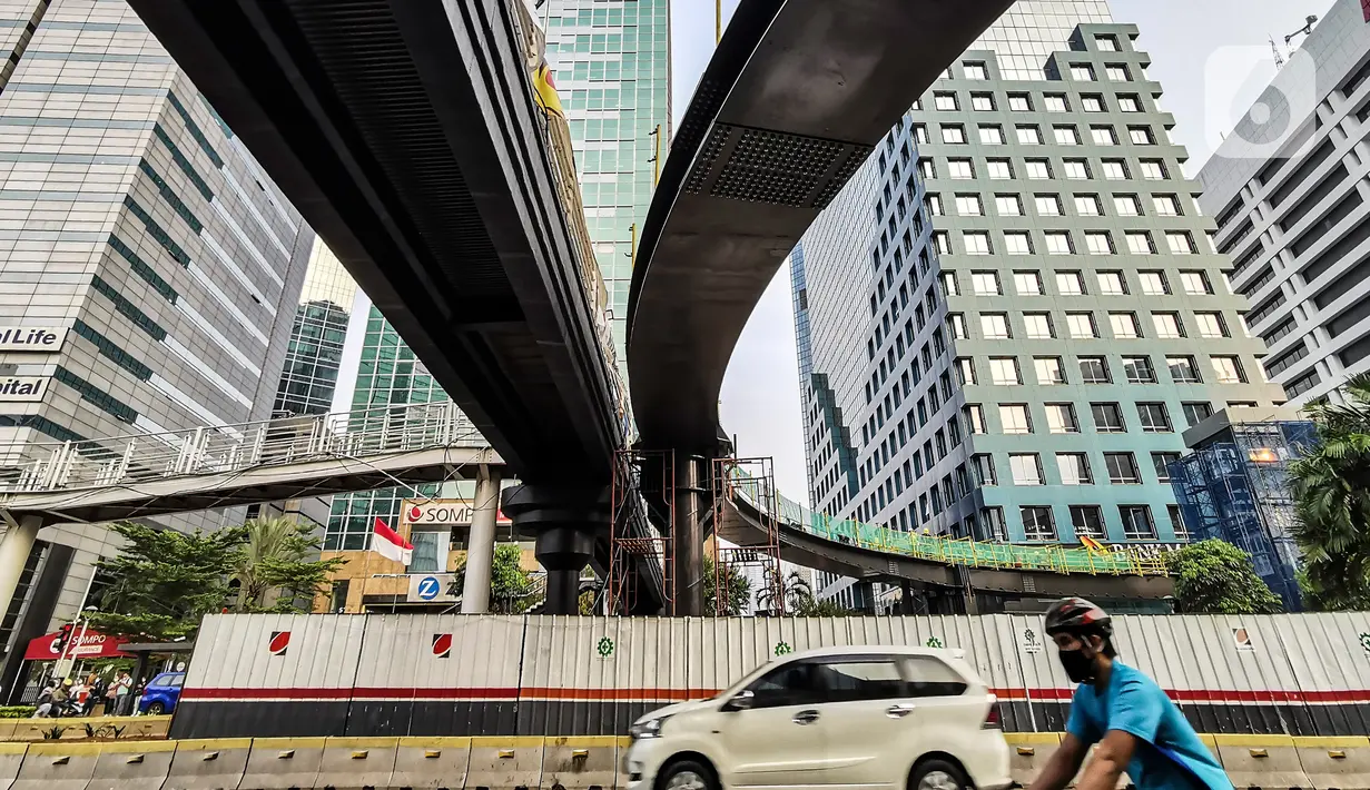 Pekerja menyelesaikan pengerjaan jembatan penyeberangan orang (JPO) dan jembatan penyeberangan sepeda di Karet Sudirman, Jakarta, Jumat (8/10/2021). Jembatan penyeberangan dengan konsep modern yang dilengkapi anjungan bertema kapal pinisi ini sudah mencapai 70 persen. (Liputan6.com/Johan Tallo)