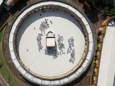 Sebuah gambar udara menunjukkan calon jemaah haji Indonesia berlatih ritual tawaf mengelilingi replika Ka'bah, selama sesi pelatihan di Pusat Pelatihan Manasik Al Mahmudah (AMTC) di Tangerang Selatan pada 5 April 2026. Presiden Prabowo Subianto memutuskan untuk menurunkan biaya haji 2026 sebesar Rp 2 juta. (Foto oleh AFP)