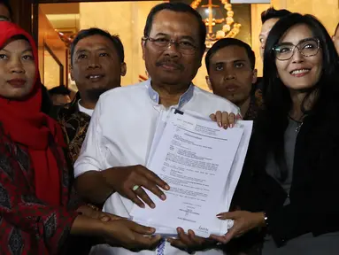 Jaksa Agung HM Prasetyo (tengah) menerima surat jaminan penangguhan eksekusi terhadap terpidana kasus pelanggaran UU ITE, Baiq Nuril Maknun(kiri)  dari anggota DPR Fraksi PDIP Rieke Diah Pitaloka di gedung Kejaksaan Agung, Jakarta, Jumat (12/7/2019). (Liputan6.com/Johan Tallo)
