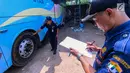 Petugas BPTD wilayah Banten Kementerian Perhubungan mengecek bagian ban bus di Pool Blue Star, Pondok Cabe, Rabu (30/5). (Merdeka.com/Arie Basuki)