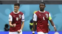 Selebrasi pemain Timnas Austria, Christoph Baumgartner (kiri) dan David Alaba usai menjebol gawang Ukraina dalam pertandingan Grup C Euro 2020 antara Ukraina melawan Austria di National Arena stadium, Selasa (22/6/2021). (Foto: AFP/Pool/Daniel Mihailescu)