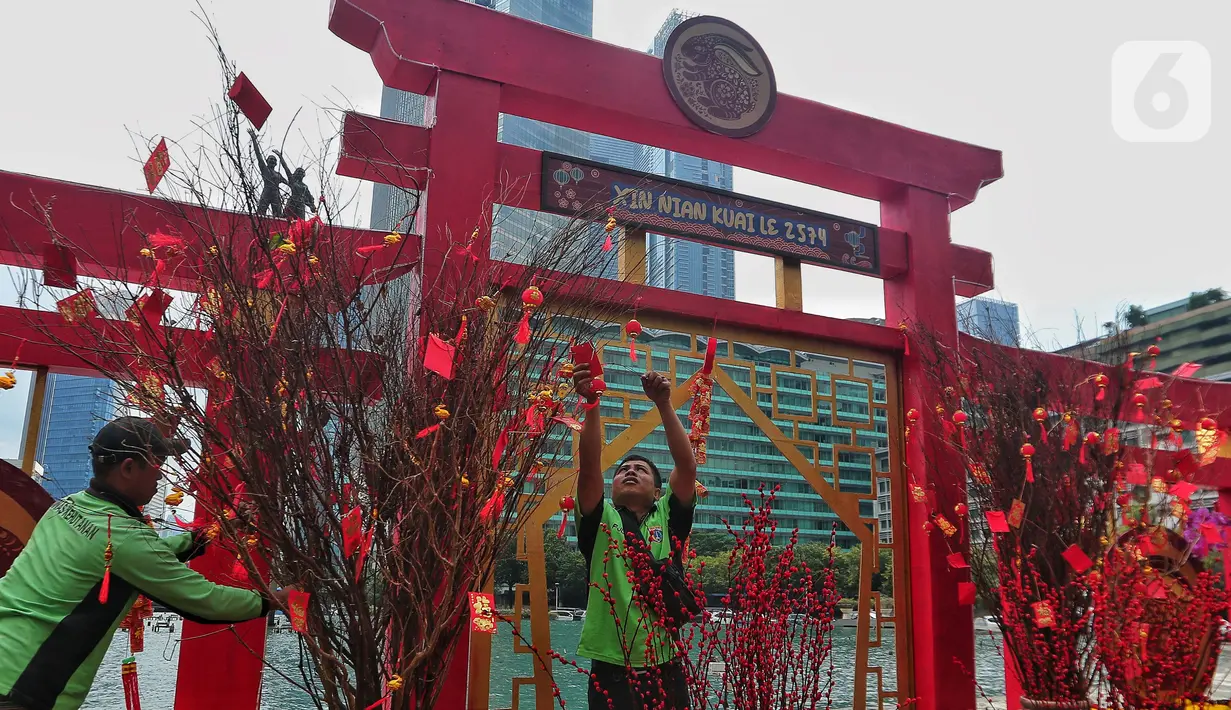 Pekerja menata ornamen pernak pernik imlek di kawasan Bundaran HI (Hotel Indonesia), Jakarta, Sabtu (21/1/2023). Ornamen tersebut dipasang dalam rangka menyambut perayaan Tahun Baru Imlek 2574 Kongzili yang jatuh pada tanggal 22 Januari 2023 besok. (Liputan6.com/Angga Yuniar)