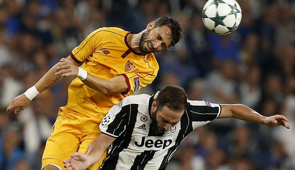 Striker Juventus, Gonzalo Higuain, berebut bola dengan pemain Sevilla, Vicente Iborra, pada laga Liga Champions Grup H di Juventus Stadium, Turin, Kami (15/9/2016) dini hari WIB. (AFP/Marco Bertorello)
