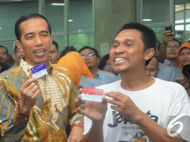 Presiden Jokowi bersama seorang warga menunjukkan Kartu Indonesia Sehat di Kantor Pos Pasar Baru, Jakarta, Senin (3/11/2014). (Liputan6.com/Herman Zakharia)
