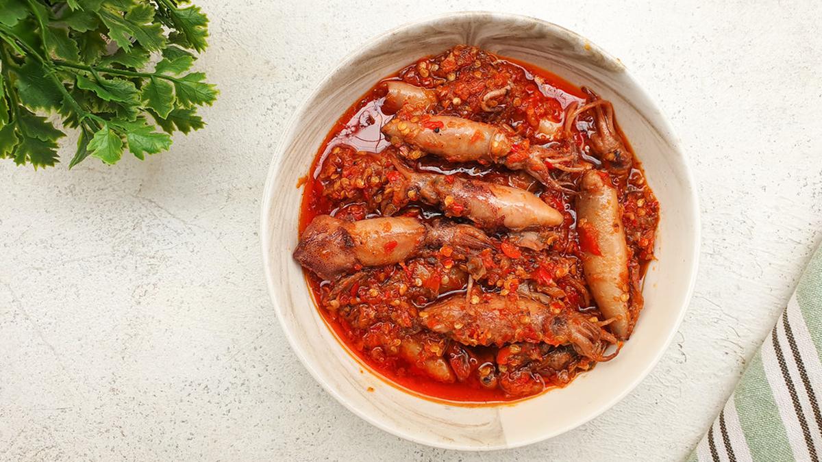 Foto cumi sambal balado disajikan di atas piring putih dengan warna merah cerah dari sambal yang menggugah selera