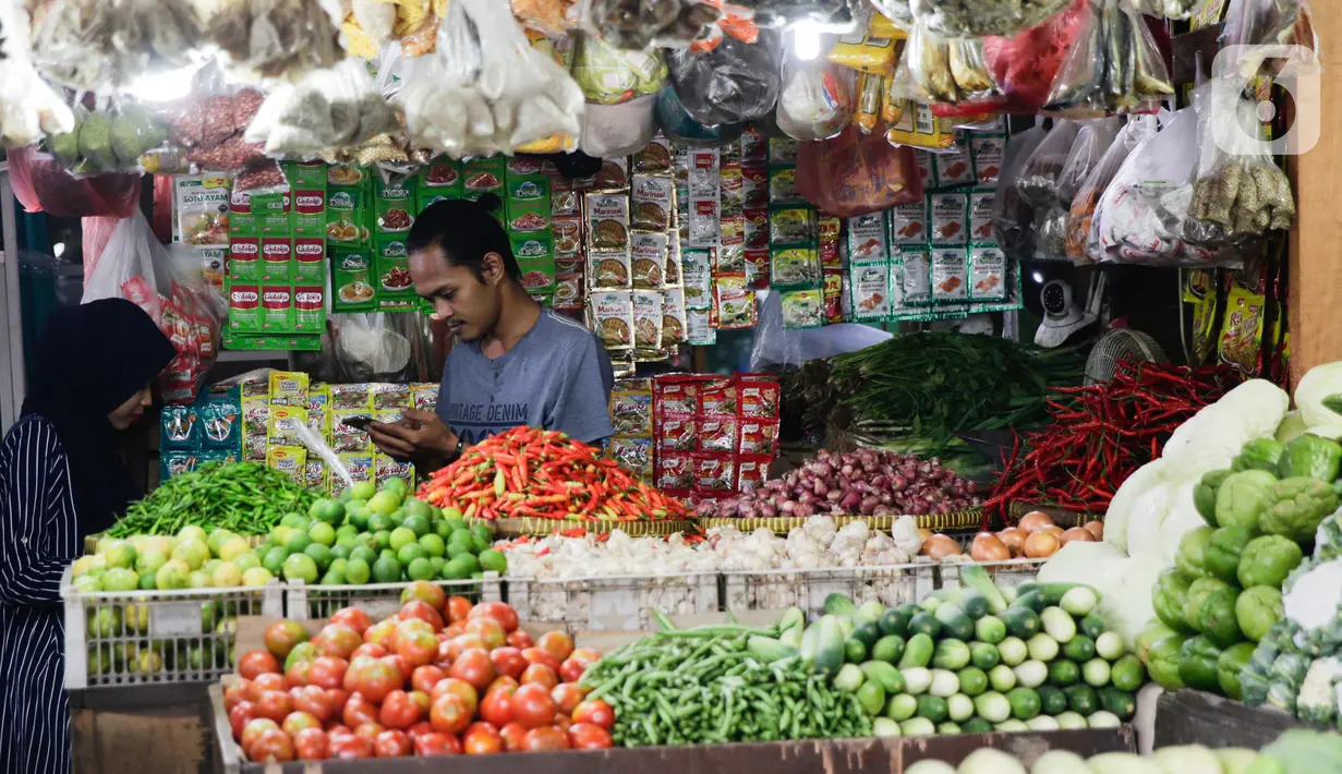 Pedagang melayani pembeli kebutuhan pokok di kiosnya di Pasar Lembang, Tangerang, Selasa (24/8/2021). Bank Indonesia (BI) memperkirakan, Indeks Harga Konsumen (IHK) alias inflasi akan berlanjut pada bulan Agustus 2021. (Liputan6.com/Angga Yuniar)