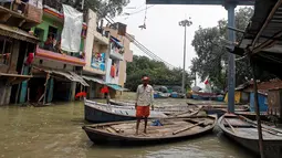 Selain menewaskan sekitar 300 jiwa, banjir bandang di India juga menenggelamkan jalan sehingga warga menggunakan perahu sebagai moda transportasi, Allahabad, India (26/8). (REUTERS/Jitendra Prakash)