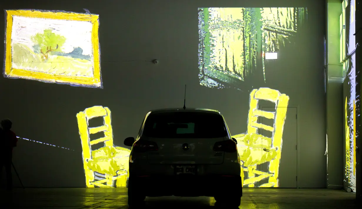 Orang-orang duduk di mobil mereka menikmati pameran seni Vincent Van Gogh di Toronto, Ontario, Kanada pada 3 Juli 2020. Pameran seni di masa pandemi Covid-19 mendatangkan ide kreatif para penyelenggara kegiatan dengan memamerkan hasil karya seni lewat konsep drive-in. (Cole BURSTON/AFP)