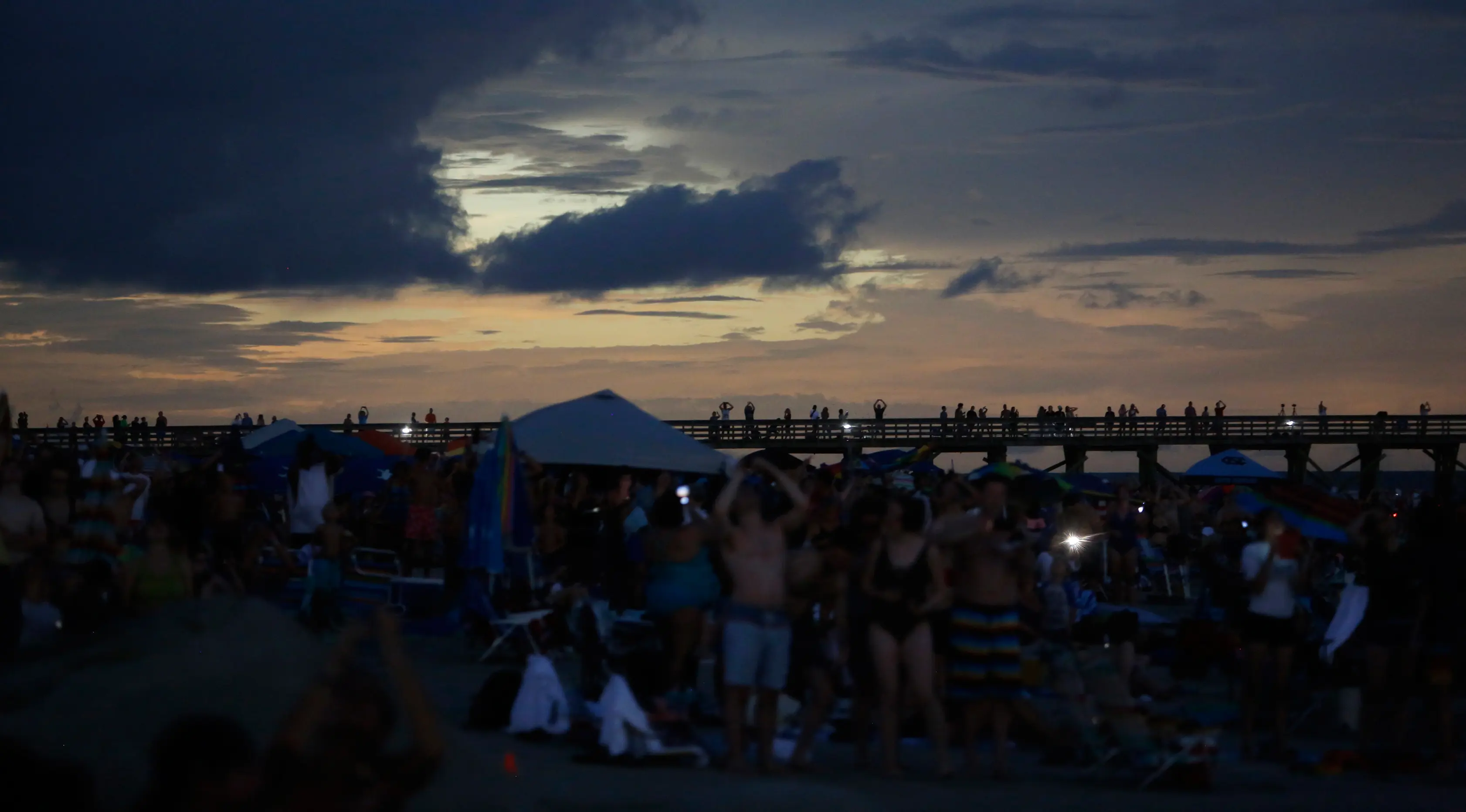 Langit di pantai Isle of Palms, South Carolina berubah menjadi gelap selama fenomena gerhana matahari, Senin (21/8). Gerhana matahari terjadi selama 100 menit dan selama dua menit kondisi langit akan gelap gulita di siang hari. (AP Photo/Mic Smith)