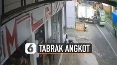Truk putih yang tengah ditinggal sopirnya meluncur dari pinggir jalan dan menabrak angkot hijau yang melintas.