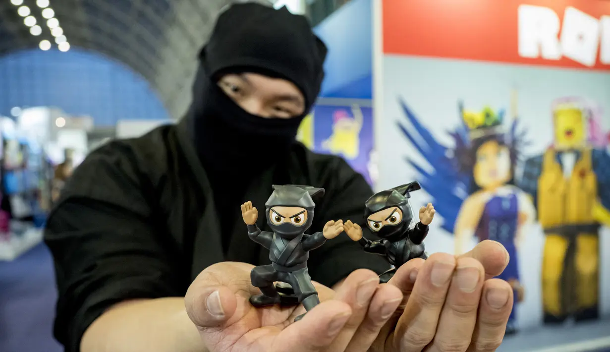 Seorang pria berkostum ninja berpose dengan mainan saat Toy Fair  atau Pameran Mainan tahunan di Olympia, London, Inggris, Selasa (23/1). (AFP PHOTO/Tolga AKMEN)