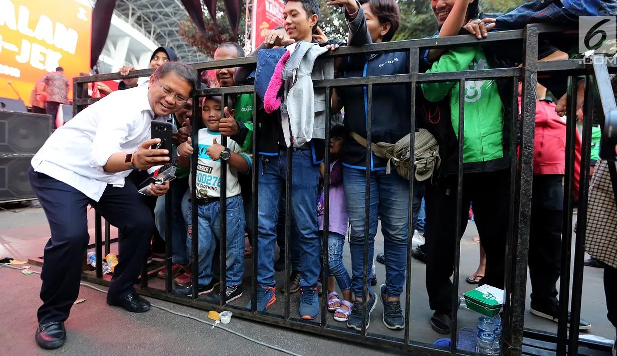 Menkominfo Rudiantara berswafoto dengan salah satu kelurga mitra GO-JEK saat menghadiri Pasar Malam di GO- FOOD Festival di GBK, Jakarta (11/5). Acara ini digelar sebagai bentuk apresiasi kepada mitra GO-JEK yang berprestasi. (Liputan6.com/Fery Pradolo)