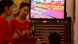 Pramusaji melayani pengunjung di sebuah restoran Korea Utara, Pyongyang Okryu-gwan di Dubai (21/9). Di restoran Pyongyang Okryu-gwan menayangkan siaran televisi Korea Utara. (AFP Photo/Giuseppe Cacace)