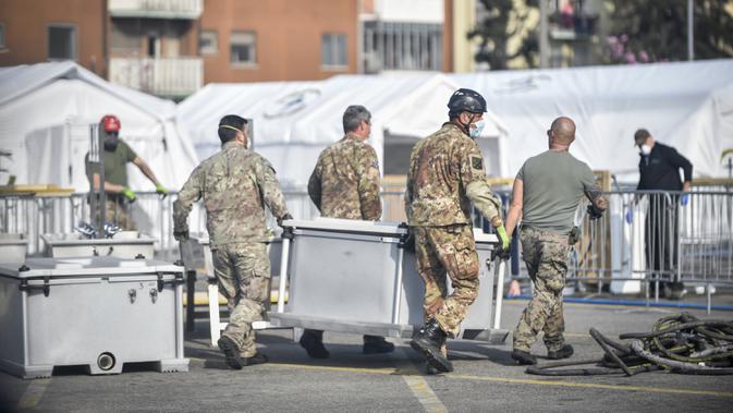 Tentara membawa peralatan rumah sakit lapangan darurat Samaritan's Purse di Cremona, Italia, Jumat, 20 Maret 2020. Rumah sakit lapangan ini dibangun untuk merawat pasien virus corona COVID-19 yang terus melonjak. (Claudio Furlan/LaPresse via AP)