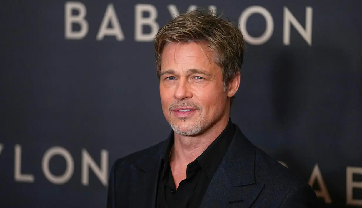 Aktor Brad Pitt berpose untuk fotografer setibanya pada acara premiere film Babylon di Paris, Prancis, 14 Januari 2023. Aktor berusia 59 tahun itu tampak tampan dalam balutan setelan serba hitam. (AP Photo/Michel Euler)