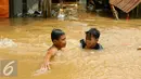 Anak-anak bermain di lokasi banjir yang merendam kawasan Kampung Pulo, Jakarta, Rabu (25/11). Air aliran kali Ciliwung mulai memasuki rumah warga sekitar pukul 03.00 Wib dini hari tadi. (Liputan6.com/Yoppy Renato)