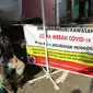 Seorang pria menjaga akses masuk zona merah COVID-19 di Kelurahan Petogogan RT 006 RW 003, Jakarta, Selasa (22/6/2021). Pemerintah Provinsi DKI Jakarta memperbarui data zona pengendalian virus Corona di tingkat rukun tetangga (RT) se-Ibu Kota.  (Liputan6.com/Faizal Fanani)