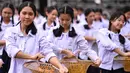 Ratusan pelajar menari saat mengikuti gladi resik di halaman sekolah di Bangkok, Thailand (13/11/2019). Gladi resik diadakan sebagai persiapan untuk kunjungan Paus Fransiskus yang  akan berada di Thailand pada 20-23 November 2019. (AFP Photo/Chalinee Thirasupa)