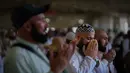 Seorang jemaah Muslim terisak-isak saat berdoa setelah melempar kerikil ke tiang-tiang sebagai simbol pelemparan batu ke setan pada hari kedua ritual, salah satu upacara terakhir ibadah haji tahunan, di Mina, Arab Saudi, Kamis 28 Mei 2026. (AP Photo/Altaf Qadri)