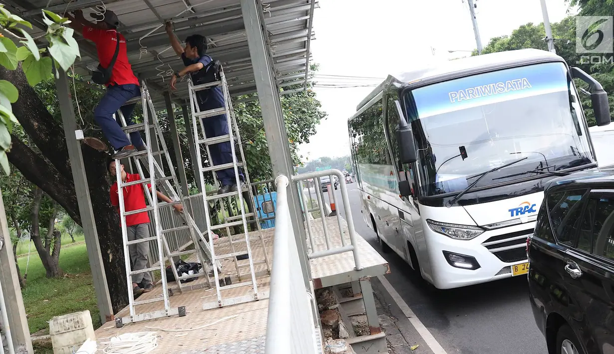 Kendaraan melintasi halte Transjakarta yang sedang dibangun di kawasan Kampung Rambutan, Jakarta, Jumat (1/3). Pembuatan halte tersebut bertujuan mempermudah warga untuk mengakses bus Transjakarta. (Liputan6.com/Immanuel Antonius)