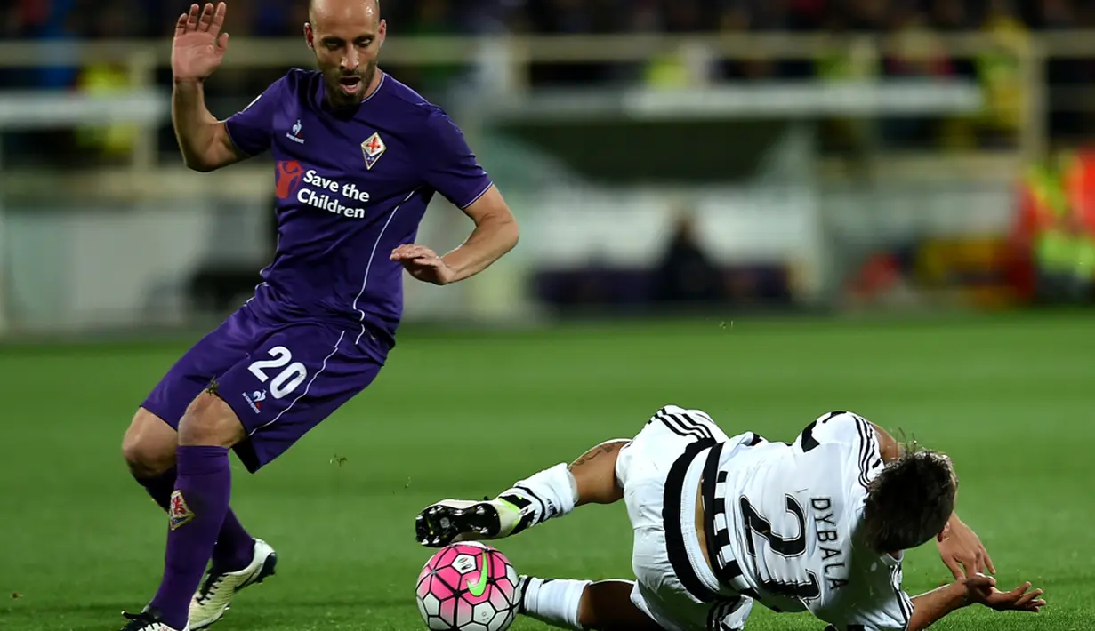 Pemain Juventus, Paulo Dybala (kanan), terjatuh saat berebut bola dengan pemain Fiorentina, Borja Valero, dalam lanjutan Serie A di Stadion Artemio Franchi, Firenze, Senin (25/4/2016) dini hari WIB. (AFP/Alberto Pizzoli)