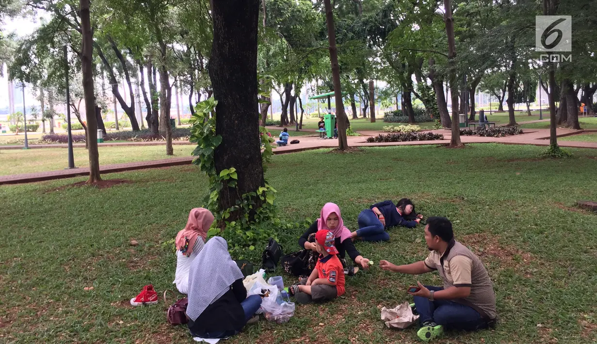 Pengunjung bercengkerama di sekitar Taman Monas, Jakarta, Rabu (17/1). Gubernur Anies Baswedan melalui Kepala Unit Pengelola Kawasan (UPK) Monas mencabut larangan menginjak rumput di kawasan tersebut. (Liputan6.com/Immanuel Antonius)
