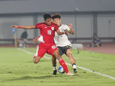 Pemain Timnas Indonesia U-17, Sean Rahman berduel dengan pemain China U-17, Kuang Zholei dalam pertandingan uji coba internasional di Indomilk Arena, Tangerang, pada Rabu (11/2/2026) malam WIB. (Bola.com/Abdul Aziz)