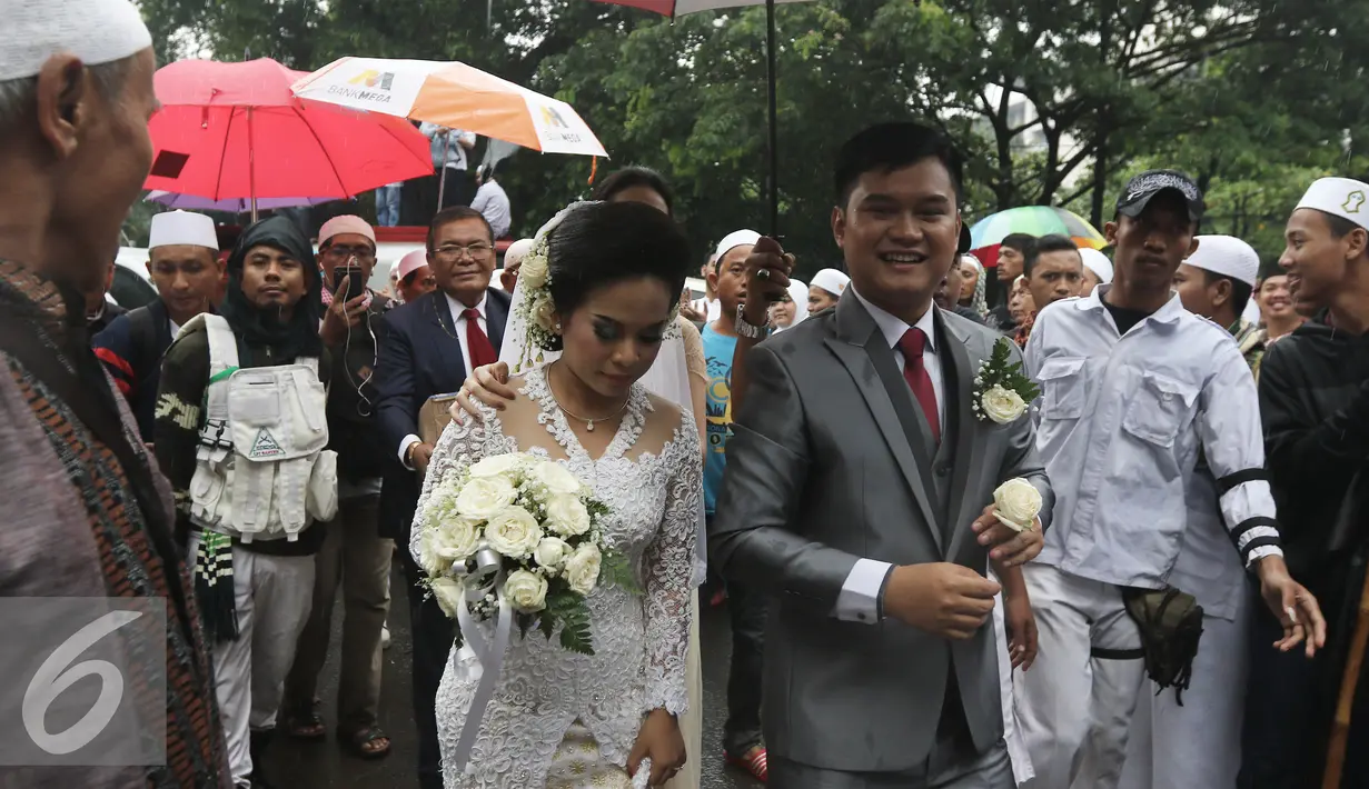 Suasana saat sepasang mempelai yang dikawal sejumlah orang dari ormas untuk menuju Gereja Katedreal, Sabtu (11/2). Pasangan ini diberi jalan oleh umat muslim untuk melangsungkan pemberkatan di gereja katedral. (Liputan6.com/Herman Zakharia)
