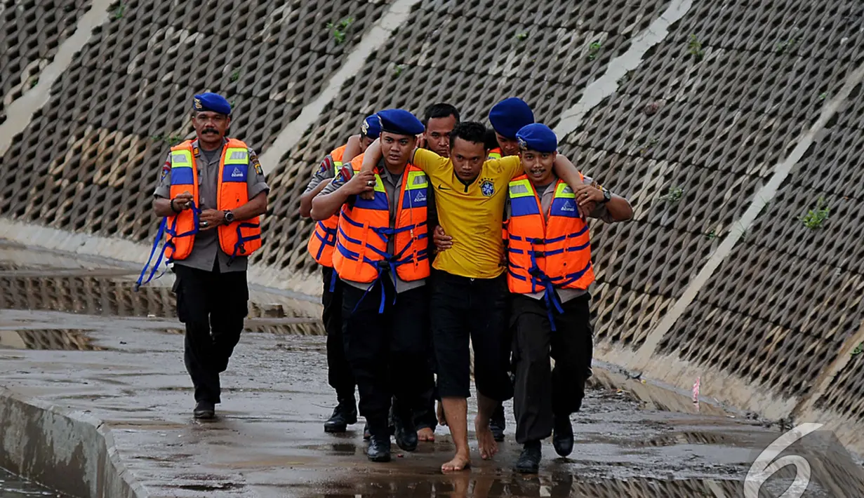 Seorang warga berhasil diselamatkan petugas dalam simulasi penyelamatan saat banjir, Kampung Pulo, Jakarta, Selasa (13/1/2015). (Liputan6.com/Johan Tallo)