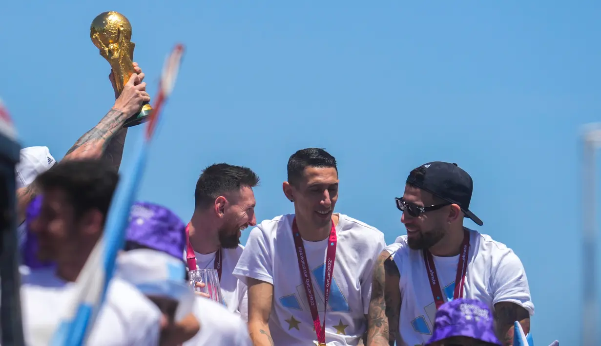 Pemain Argentina Lionel Messi (kiri) berbincang dengan rekan setimnya Angel Di Maria (tengah) dan Nicolas Otamendi di atas bus saat parade usai menjuarai Piala Dunia 2022 di Buenos Aires, Argentina, 20 Desember 2022. Jutaan orang menyambut kepulangan Lionel Messi dan kawan-kawan bak pahlawan usai Argentina menjuarai Piala Dunia 2022. (AP Photo/Natacha Pisarenko)