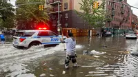 Seorang pria bekerja membersihkan saluran air akibat banjir di wilayah Brooklyn, New York, Amerika Serikat, Jumat (29/9/2023). Hujan badai yang dahsyat pada jam-jam sibuk telah melanda wilayah metropolitan New York. (AP Photo/Jake Offenhartz)