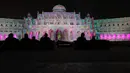 Pengunjung mengambil gambar bangunan ikonik kota Sharjah yang diterangi lampu warna-warni selama festival cahaya Sharjah di Uni Emirat Arab, 13 Februari 2019. Festival cahaya tahunan ini menampilkan kombinasi desain cahaya tiga dimensi. (KARIM SAHIB/AFP)