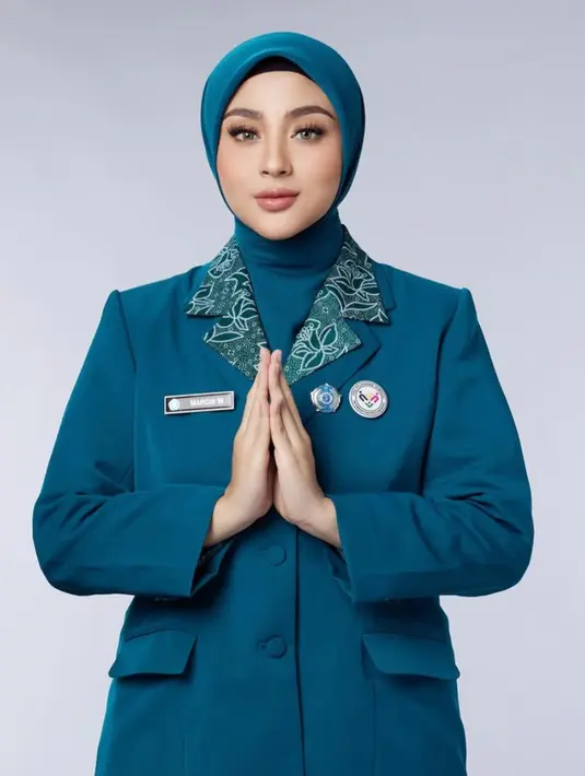 Lengkap mengenakan name tag dan pin lambang PKK. Ia juga mengenakan kerudung biru yang dimasukan ke dalam kemeja nya. [@aldiphotoofficial]