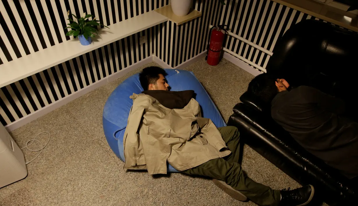Seorang pegawai terlihat sangat nyenyak ketika tidur siang pada jam istirahat di kantornya, di Beijing, China, (21/4). Tidur siang dilakukan untuk meningkatkan produktivitas kinerja para pegawai. (REUTERS/Jason Lee)