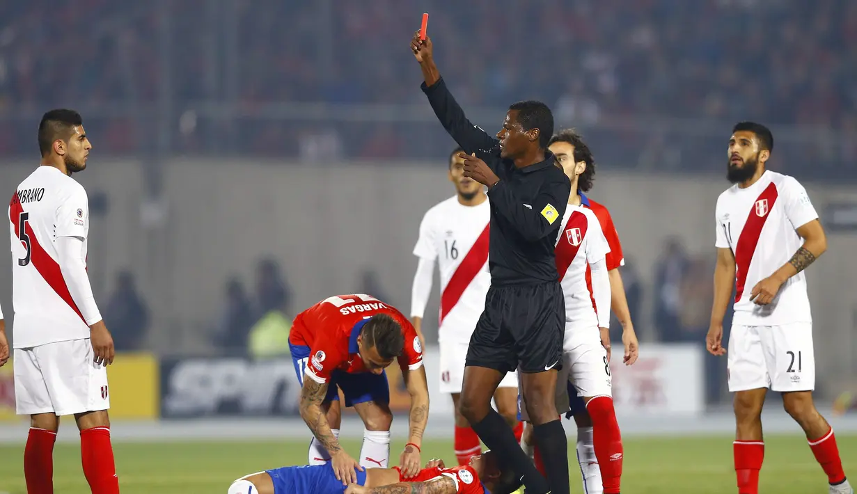 Wasit Jose Argote memberikan kartu merah kepada pemain Peru, Carlos Augusto Zambrano (kiri) setelah menendang punggung pemain Cile, Charles Aranguiz. (EPA/Javier Valdes)