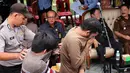 Petugas mengawal dua terpidana kasus liwath alias gay di sebuah masjid di Banda Aceh, Indonesia (23/5). Dua orang pria tersebut menerima hukuman cambuk sebanyak 85 kali karena melakukan hubungan seks homoseksual. (AP Photo / Heri Juanda, File)