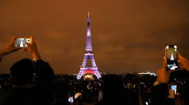 Wisatawan mengambil gambar Menara Eiffel yang berhias instalasi cahaya warna-warni di Paris, Perancis, Kamis (13/9). Pertunjukan ini untuk merayakan 160 tahun hubungan diplomatik antara Perancis dengan Jepang. (AP Photo/Christophe Ena)