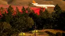 Sebuah pesawat berusaha memadamkan api yang membakar kawasan Sonoma, California, Amerika Serikat, Sabtu (26/10/2019). Kebakaran telah menghanguskan ribuan hektare lahan. (AP Photo/Nuh Berger)