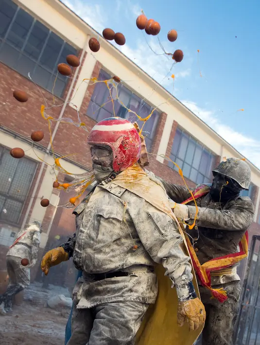 <p>Orang-orang yang bersuka ria mengenakan pakaian militer tiruan saat ikut serta dalam perang makanan "Els Enfarinats" di Kota Ibi, Spanyol, 28 Desember 2022. Para peserta dalam festival ini dikenal sebagai Els Enfarinats (mereka berlumuran tepung).(JAIME REINA/AFP)</p>